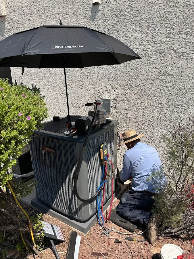 HVAC technician performing outdoor AC maintenance in Redlands